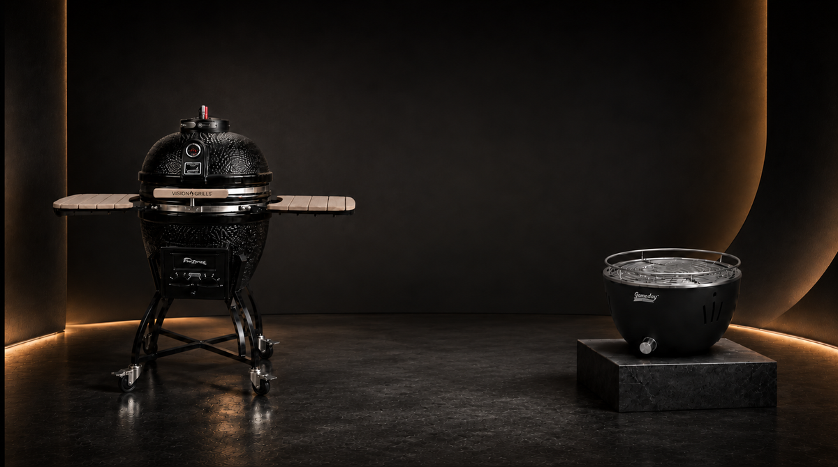 Asador kamado negro Vision Grills y asador portátil Gameday en un estudio oscuro con iluminación cálida